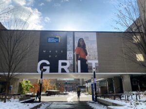 A photo of a building on the Toronto Metropolitan university campus. There is wall art on the building saying 'Made of GRIT."